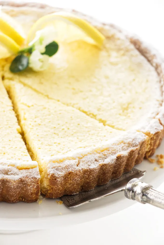 Close up view of a cut slice of lemon tart being served
