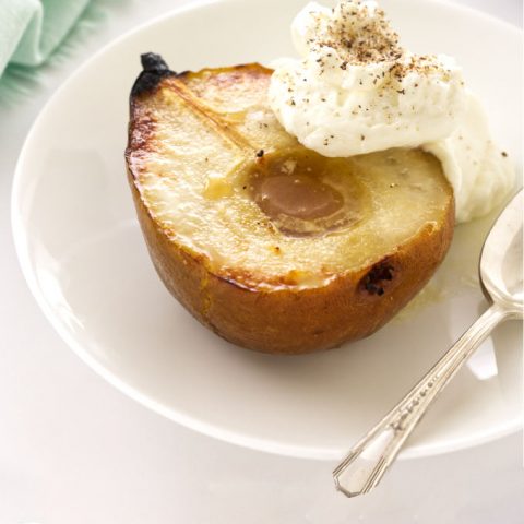 Roasted pear with whipped mascarpone cream on serving plate