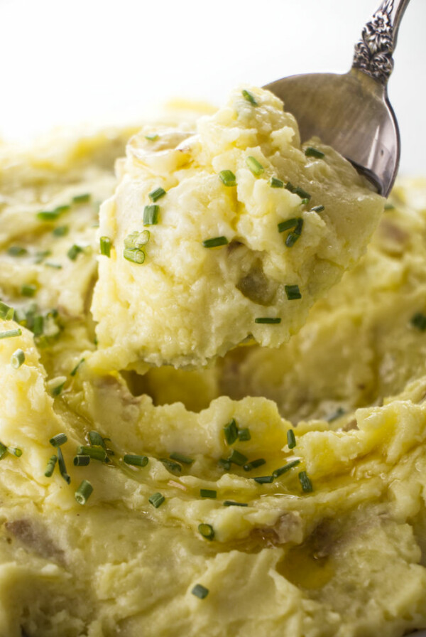 A spoon scooping some mashed creamer potatoes.