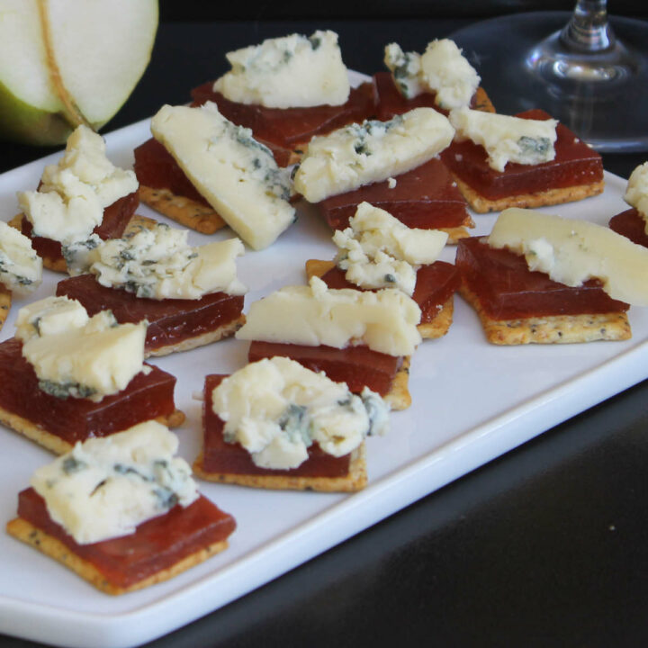 Pear paste on a cheese board with crackers and cheese.