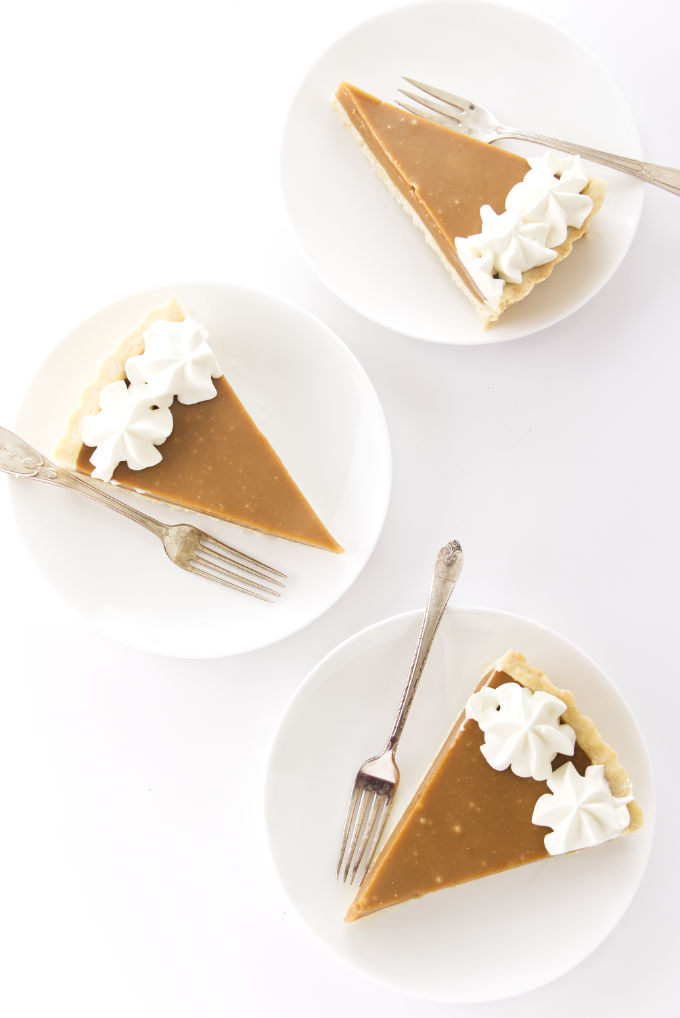 Three slices of butterscotch tart on plates.
