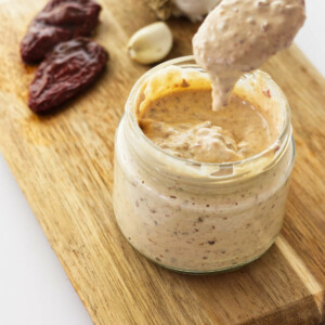 A spoon dipping into a jar of chipotle aioli.