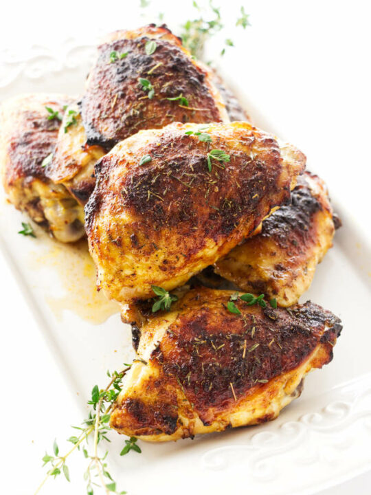 Oven roasted chicken thighs on a serving plate