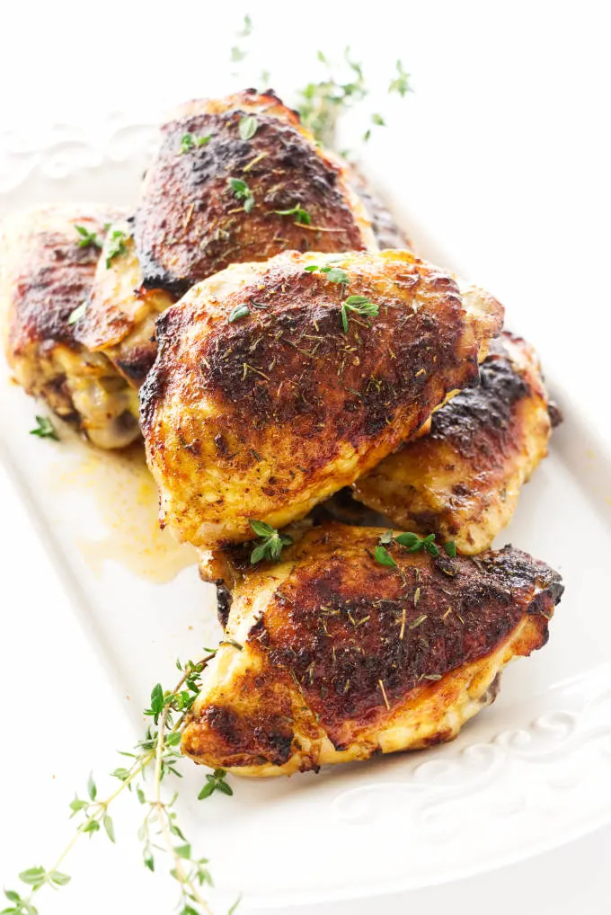 Oven roasted chicken thighs on a serving plate