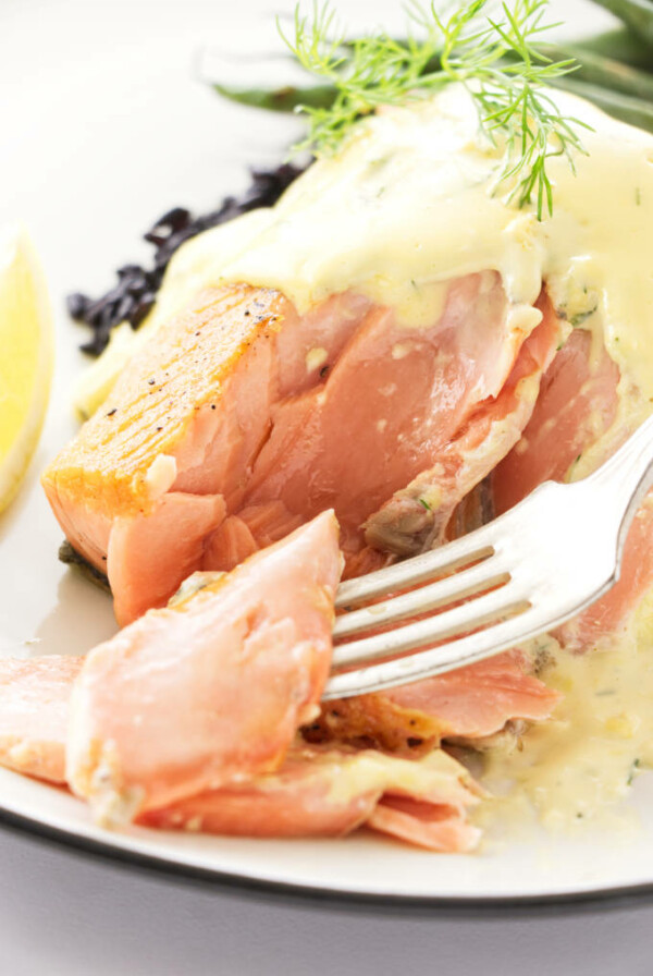 Close up view of a bite of salmon on a fork