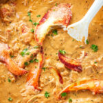 Lobster in tomato cream sauce cooking in a skillet.