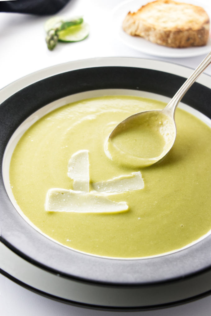 A bowl of asparagus pea soup with parmesan cheese.