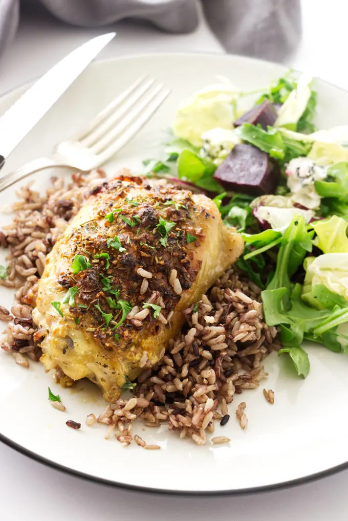 Roasted chicken thigh on a mound of wild blend rice and a side salad