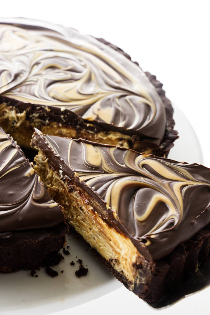 A peanut butter cup tart being sliced and served.