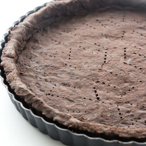 A chocolate shortbread crust in a tart pan.