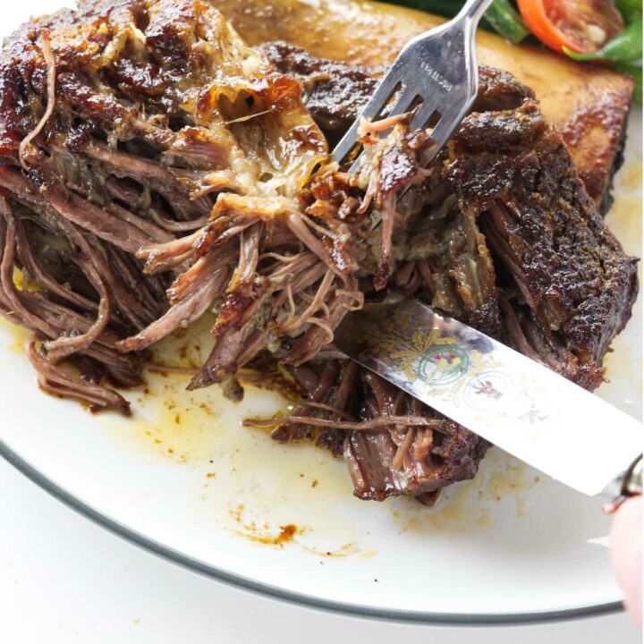 A beef rib being shred with a fork.
