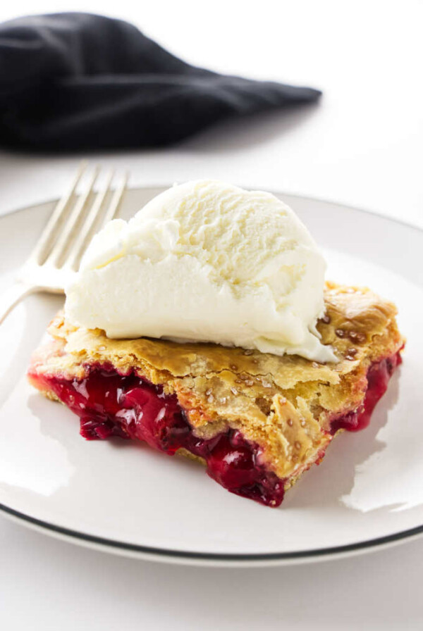 A serving of strawberry-rhubarb slab pie with a scoop of ice cream