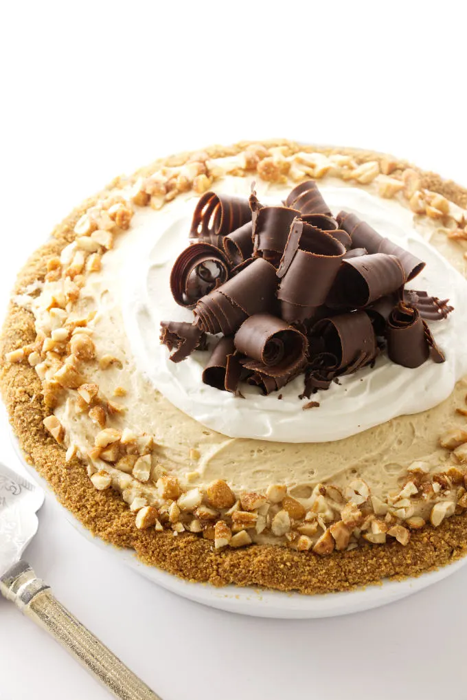 Peanut butter pie with chocolate curls and chopped peanuts.