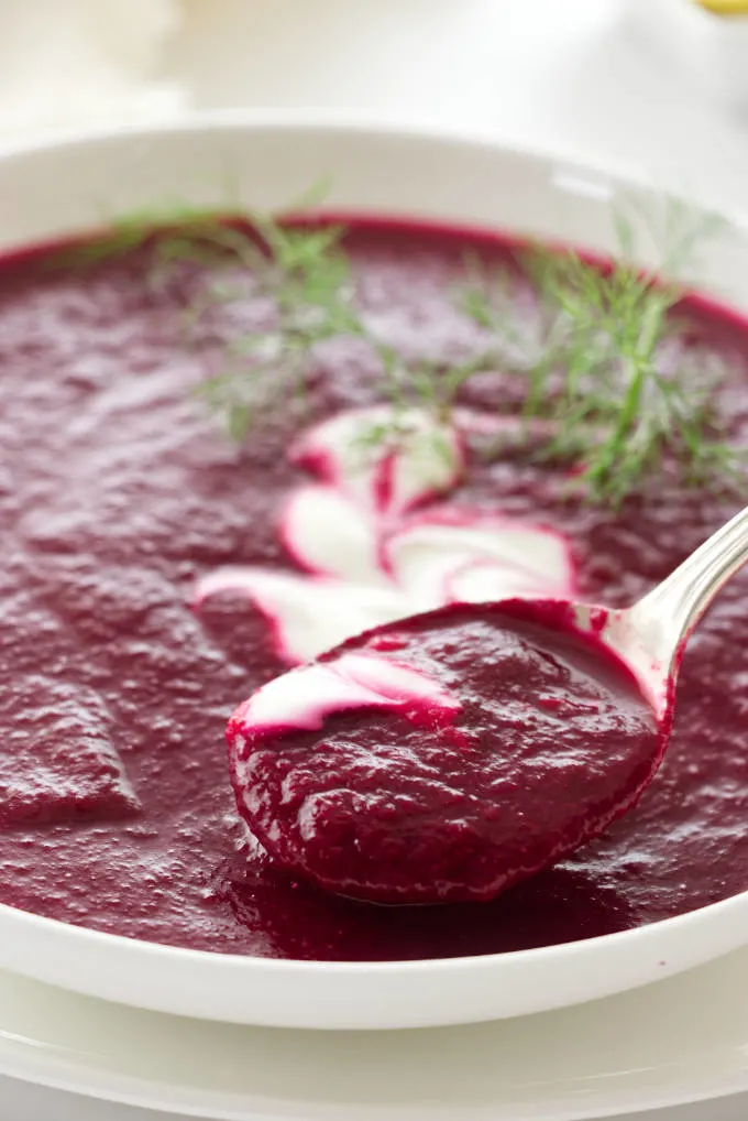 Close up view of a spoon full of roasted beet soup