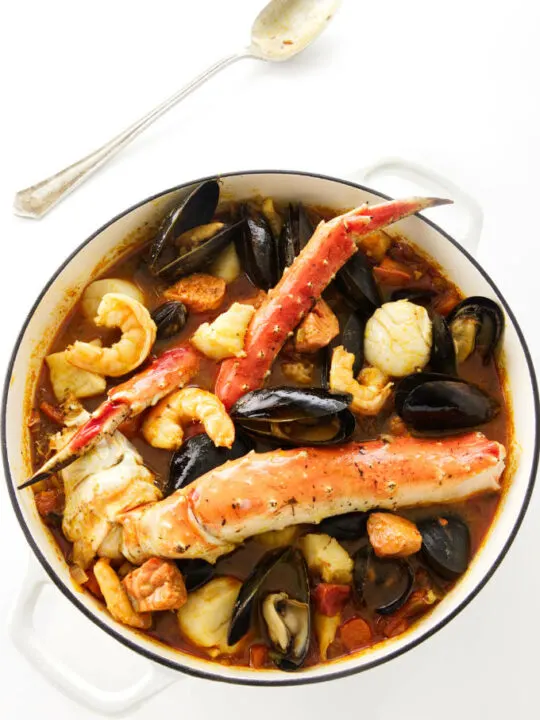 A pot of seafood stew with king crab, shrimp, scallops, mussels, halibut, and salmon.