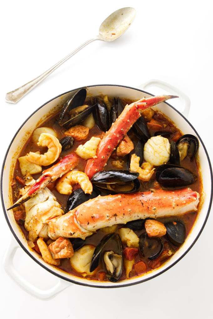 A pot of seafood stew with king crab, shrimp, scallops, mussels, halibut, and salmon.