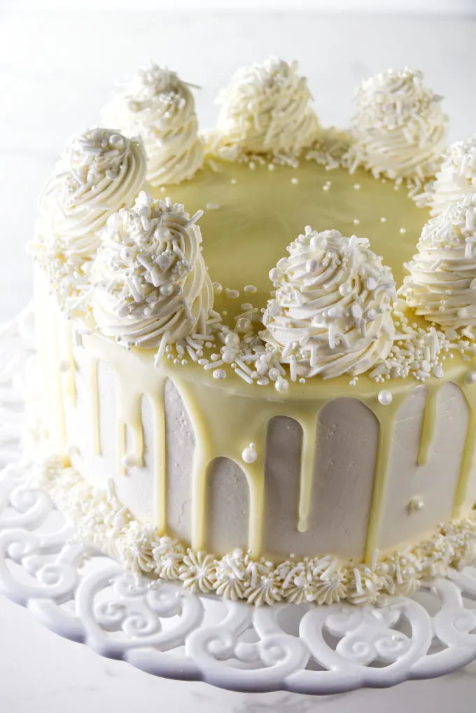 A white chocolate cake on a cake platter.