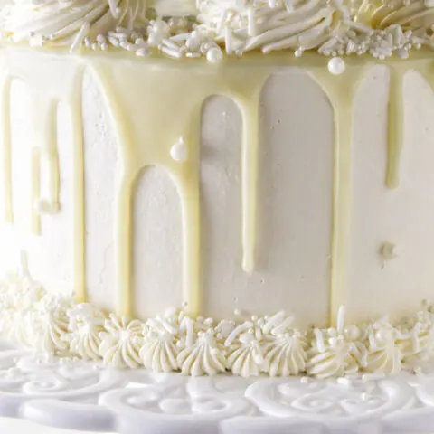 White chocolate ganache dripping down the sides of a cake.