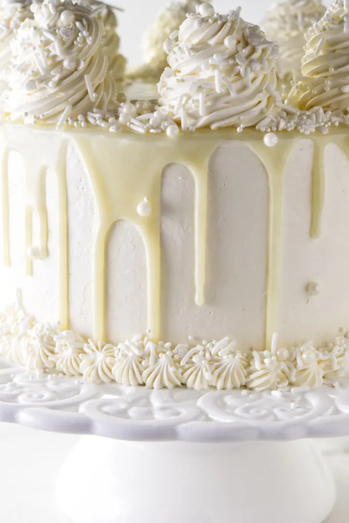 White chocolate ganache dripping down the sides of a cake.