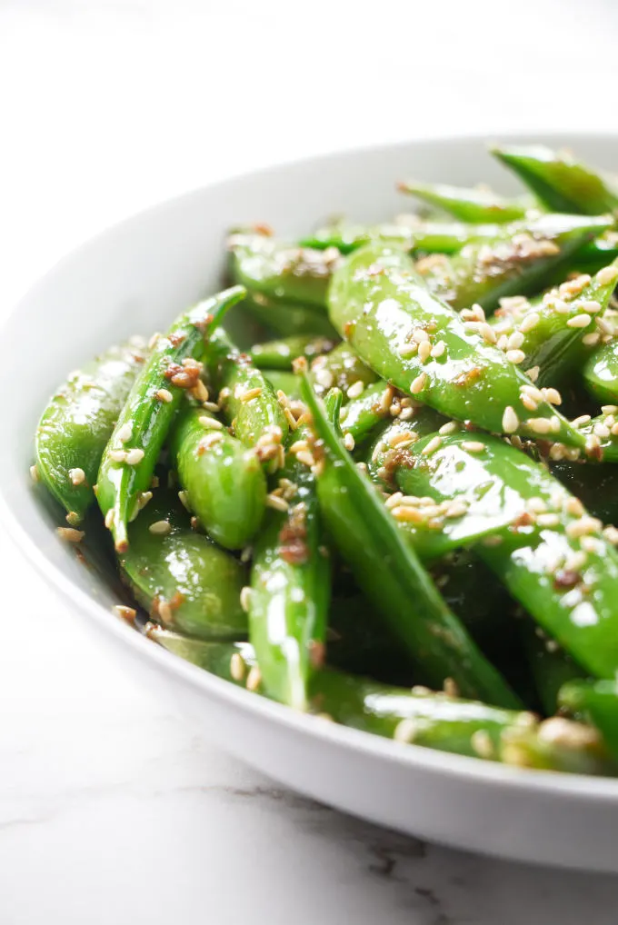 A bowl of sugar snap peas with garlic and sesame.