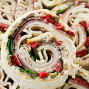 Italian pinwheel sandwich appetizers stacked on top of each other.