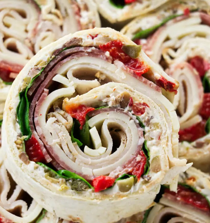 Italian pinwheel sandwich appetizers stacked on top of each other.
