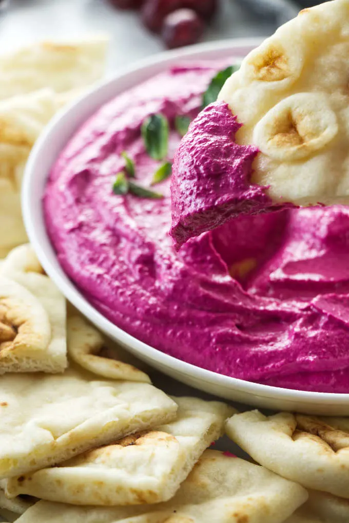 Dipping naan bread into red beet labneh.