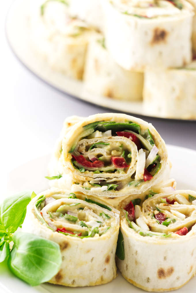 Three vegetarian pinwheels on a serving plate.