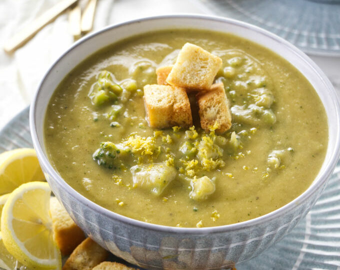 Two bowls of lemon broccoli soup with croutons.