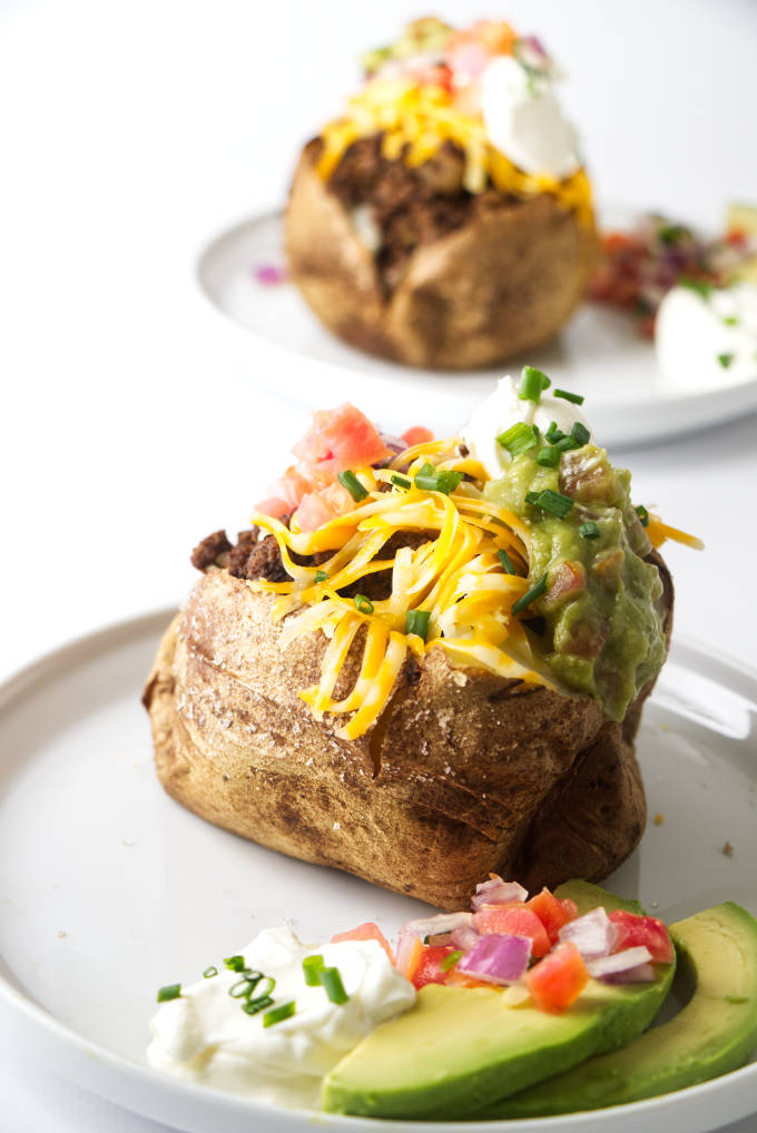 A taco stuffed baked potato on a plate.