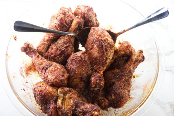Tossing drumsticks in a dry rub.