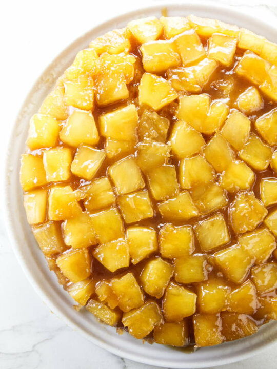 An overhead view of a pineapple upside down cake with pineapple chunks on top.