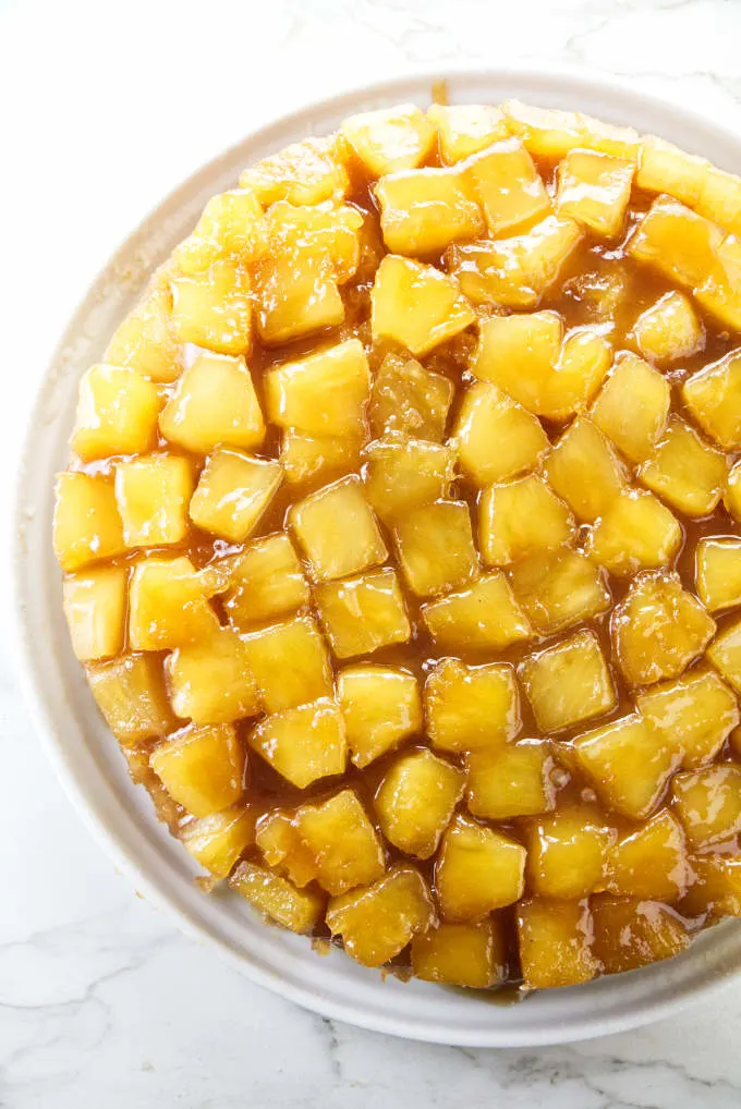 An overhead view of a pineapple upside down cake with pineapple chunks on top.