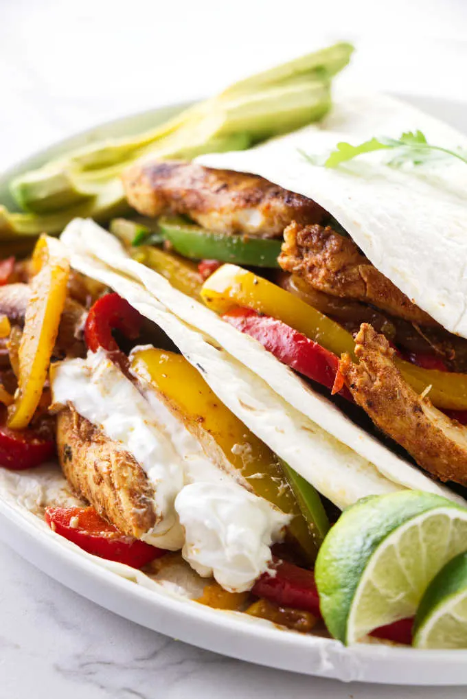 Two flour tortillas filled with chicken fajita mixture.