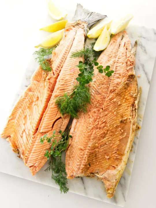 A whole baked salmon opened up on a serving platter.