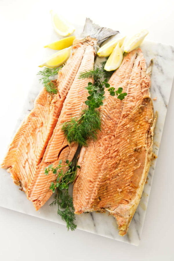 A whole baked salmon opened up on a serving platter.