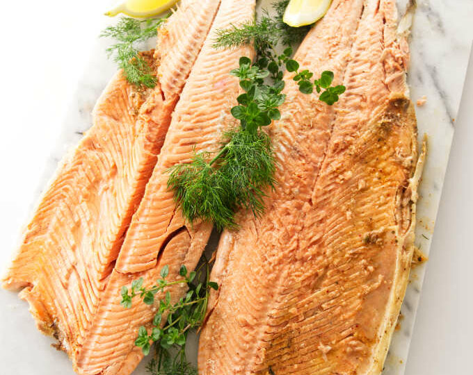 A whole baked salmon opened up on a serving platter.