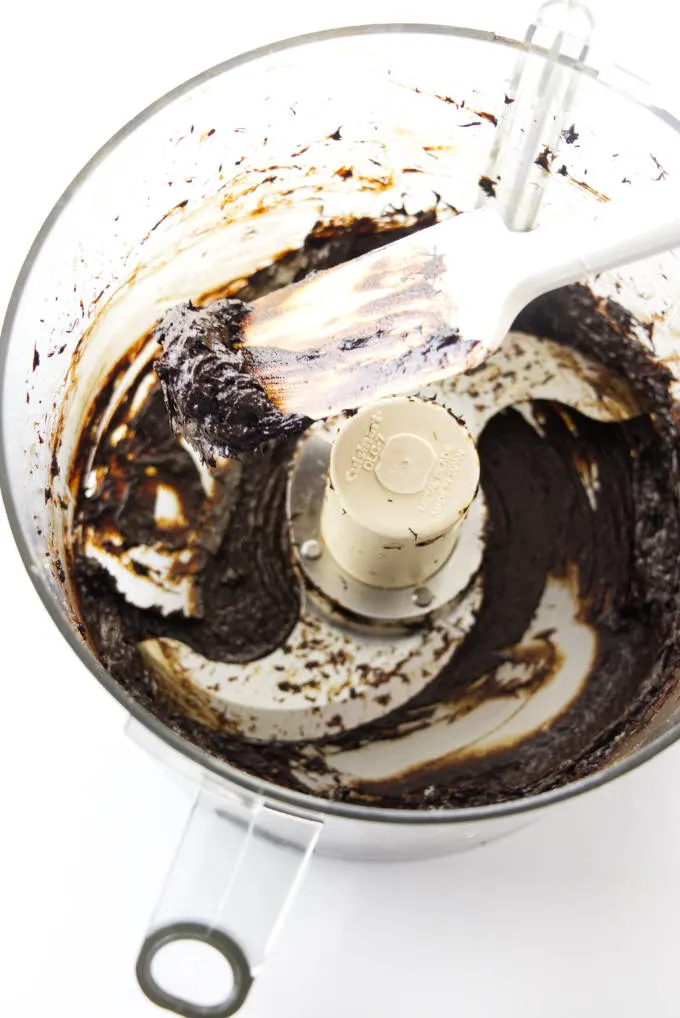 Black garlic being pureed in a food processor.