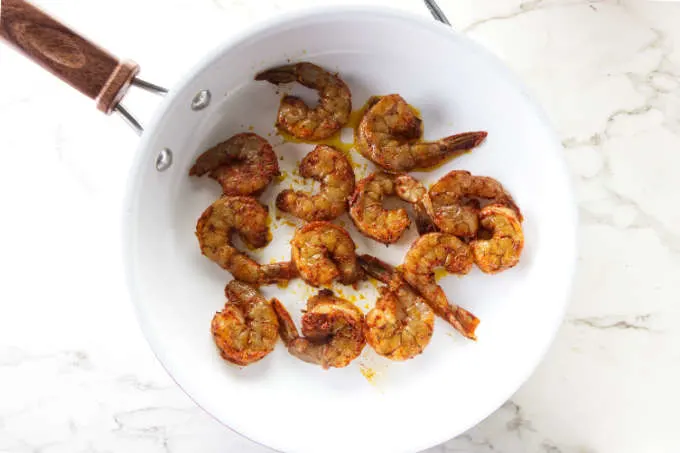 Cooking blackened shrimp in a saute pan.