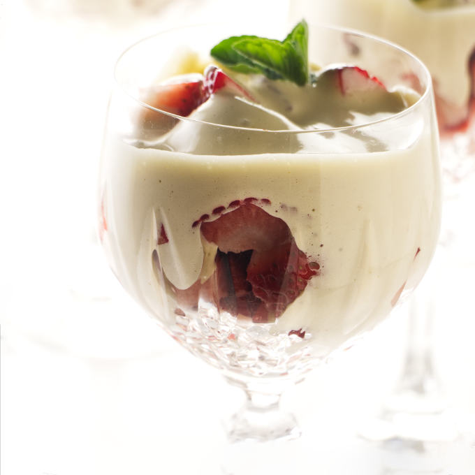 A glass filled with strawberries and zabaglione.