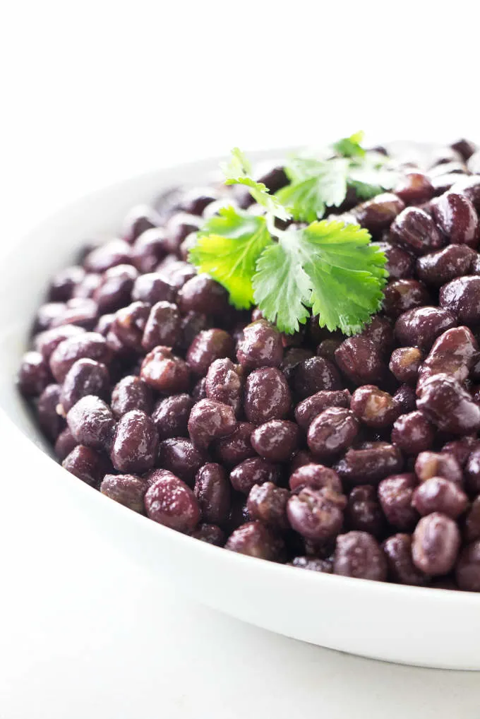 a bowl of adzuki beans with cilantro on top for garnish.