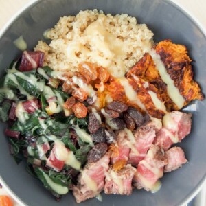 A bowl of quinoa topped with leftover beef.