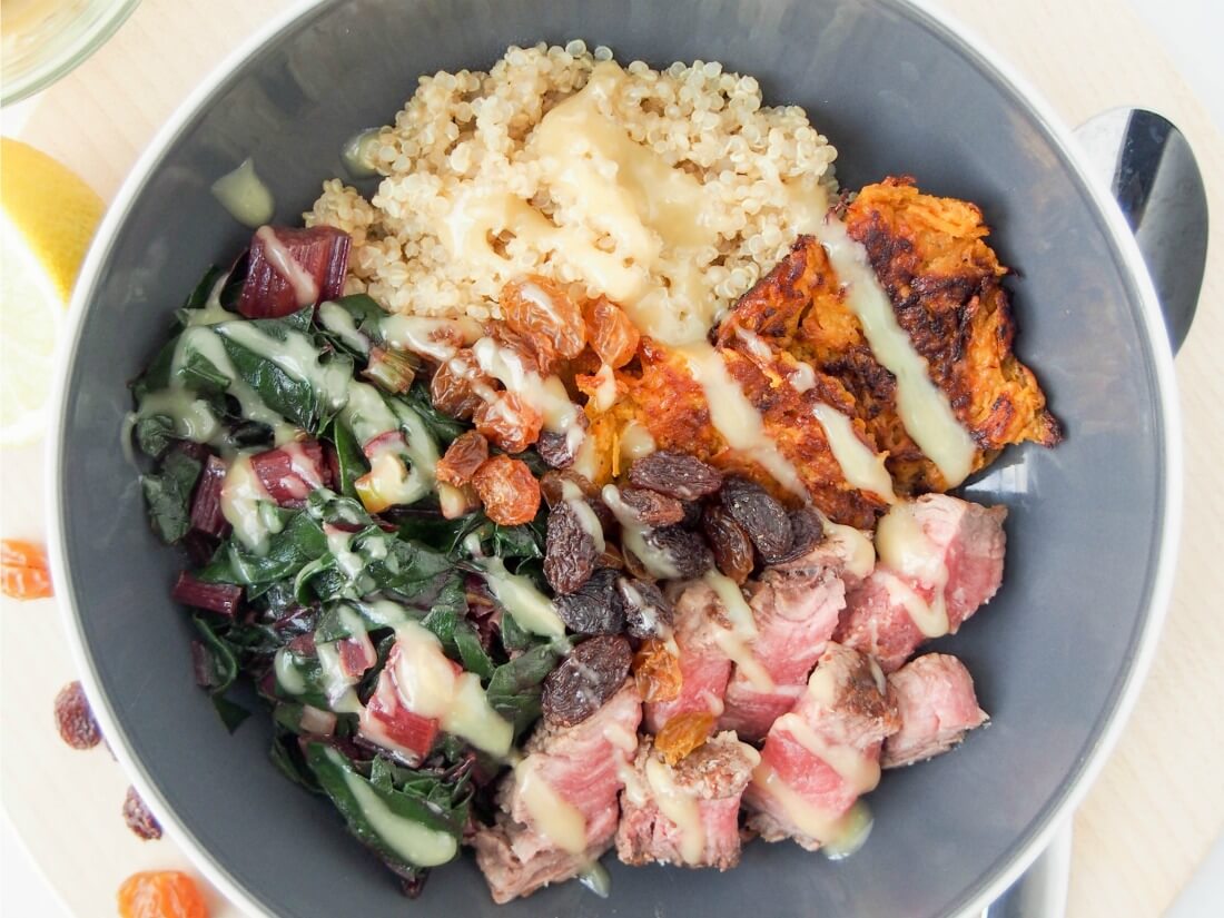 A bowl of quinoa topped with leftover beef.