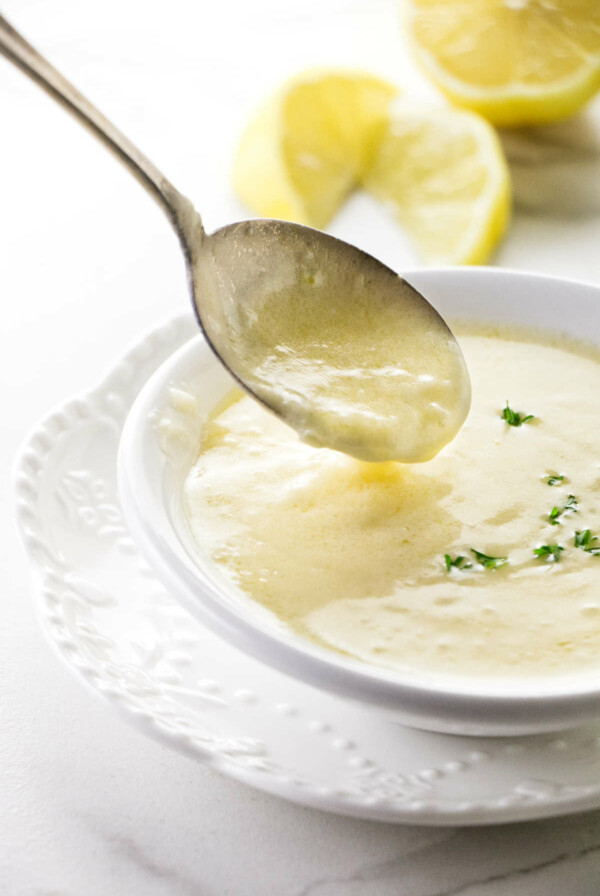 A spoon in a dish of lemon garlic butter sauce.