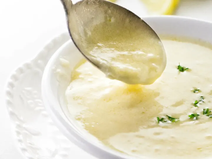 A spoon in a dish of lemon garlic butter sauce.