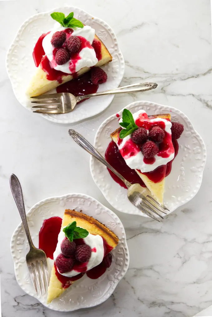 Three slices of lemon ricotta cake on white dessert plates.