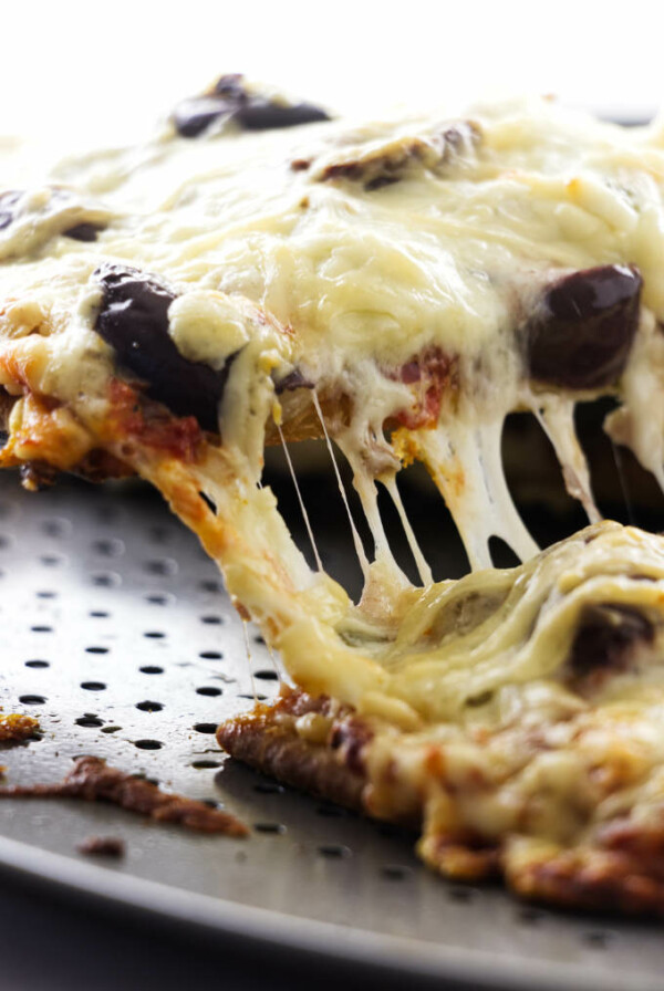 Pizza slice being lifted from pan