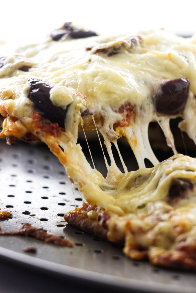 Pizza slice being lifted from pan