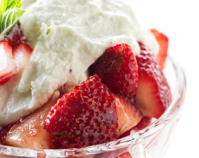 A dish of marsala strawberries with sweetened ricotta on top.