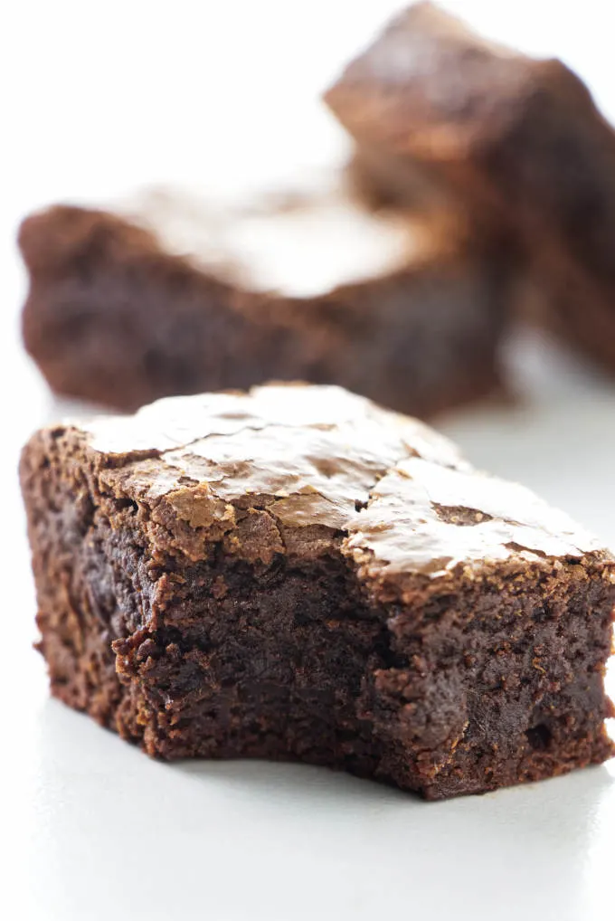 A fudgy brownie with a bite taken out of the corner.